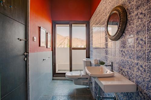 a bathroom with two toilets and a sink and a mirror at Nivaant Villa by StayAtlas in Igatpuri