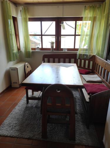 a dining room with a wooden table and a chair at Schöner Wohnen in Rheinau
