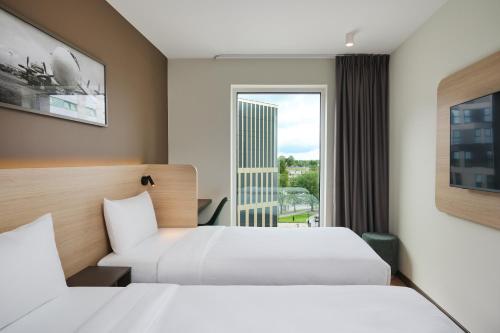 a hotel room with two beds and a window at Première Classe Warsaw Airport in Warsaw