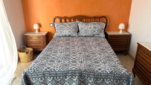 a bed in a bedroom with two nightstands and two lamps at la Casa de Flores in Tossa de Mar