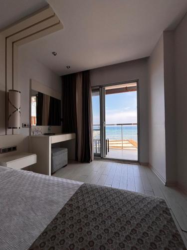 a bedroom with a bed and a view of the ocean at Çözel Sare Hotel in Güzelçamlı