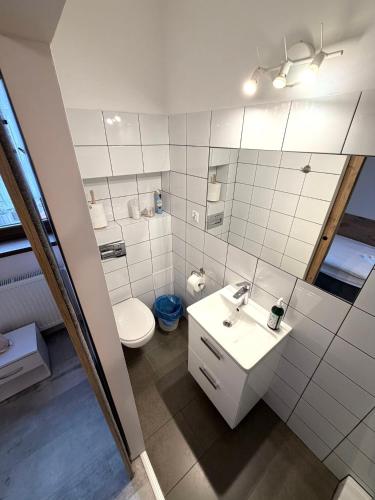 a bathroom with a toilet and a sink and a mirror at Apartamenty Jaskinia Solna in Ruda Śląska