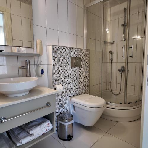 a bathroom with a toilet and a sink and a shower at Çözel Sare Hotel in Güzelçamlı