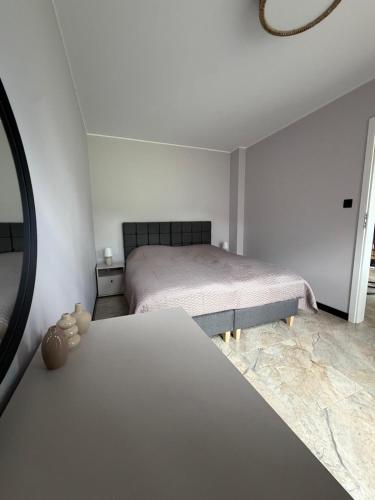 ein weißes Schlafzimmer mit Bett und Spiegel in der Unterkunft Guben Wohnungen Sunny 2 in Guben