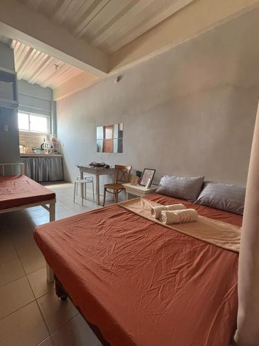a bedroom with a large bed and a table at Maru Vibe Studio unit in San Juan