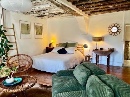 a bedroom with a bed and a couch at La chambre de la grenouille in Giverny