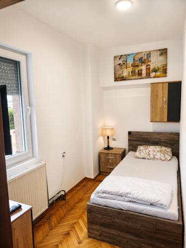 a small bedroom with a bed and a window at Garden Hostel in Skopje