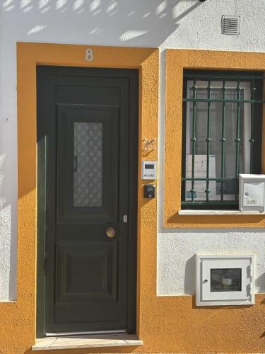 a black door on the side of a building at Casa na Aldeia in Melides