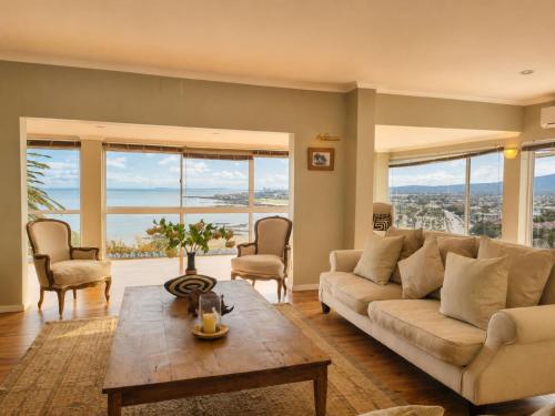 a living room with a couch and a table at Amazing View Villa, Sleeps 9 in Gordonʼs Bay