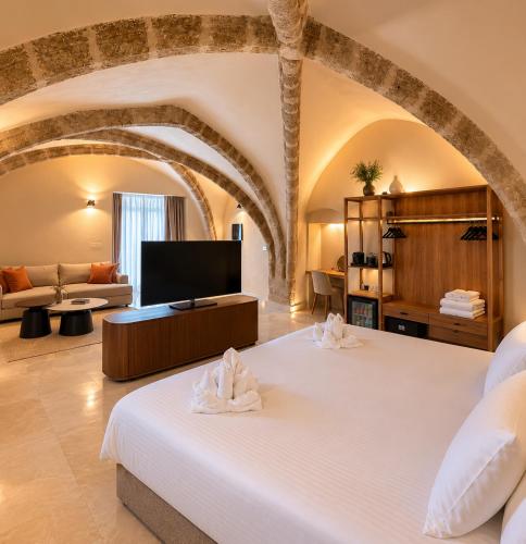 a bedroom with a bed and a living room at The Wine Suites in Rhodes Town