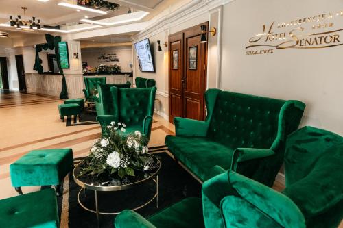a waiting room with green chairs and a couch at Hotel Senator Konferencje & SPA in Starachowice