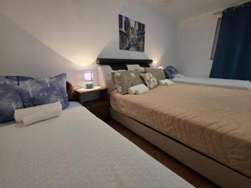 a bedroom with two beds and a table with a lamp at Garden Terrace Apartment in Igalo