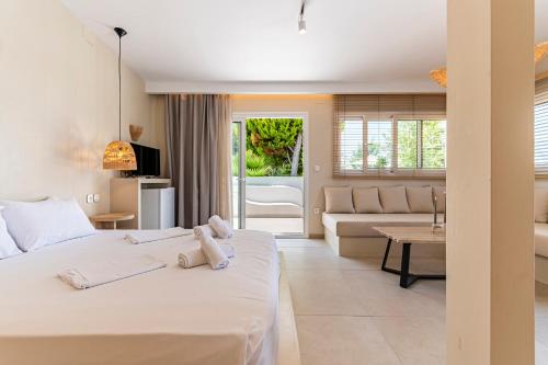 a bedroom with a bed and a living room at Haris Hotel by Diomedes Group in Hanioti