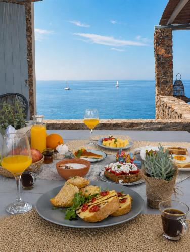 Ein Tisch mit Tellern voller Essen und Blick auf das Meer in der Unterkunft Cape Suites in Kythnos