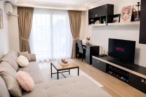a living room with a couch and a tv at WRW Airport Residence in Otopeni