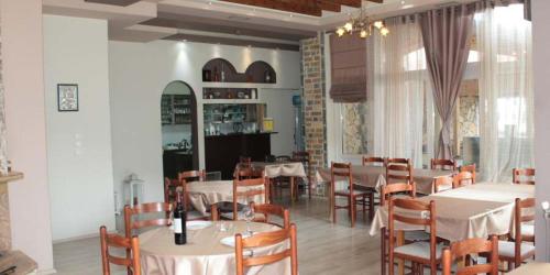 a dining room with white tables and chairs at Krystal Hotel in Krystallopigí