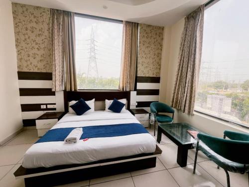 a bedroom with a bed and a large window at Crystal Park Hotel And Restaurant in Lalru