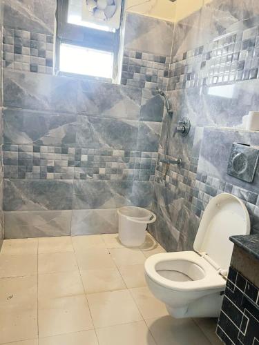 a bathroom with a toilet and a window at Crystal Park Hotel And Restaurant in Lalru