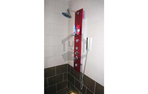 a shower in a bathroom with a red fire extinguisher at CUKROS Villa in Cserkeszőlő
