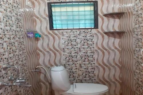 a bathroom with a toilet and a window at Hills View Stay in Māvingundi