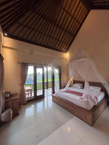a bedroom with a bed with a mosquito net at Intan Villa & Suite Ubud in Ubud