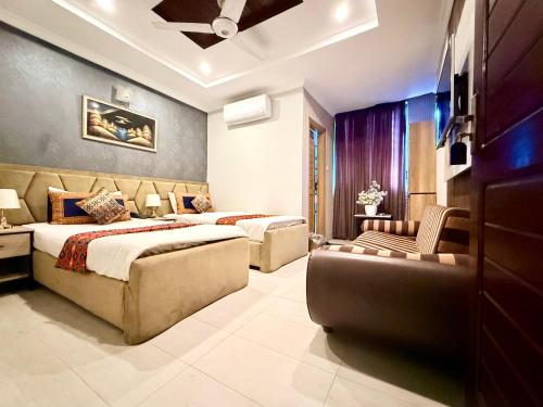a bedroom with two beds and a couch at Hotel Islamabad Premiere Inn in Islamabad