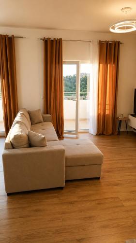 a living room with a couch in front of a window at Sunset Terrace in Durrës