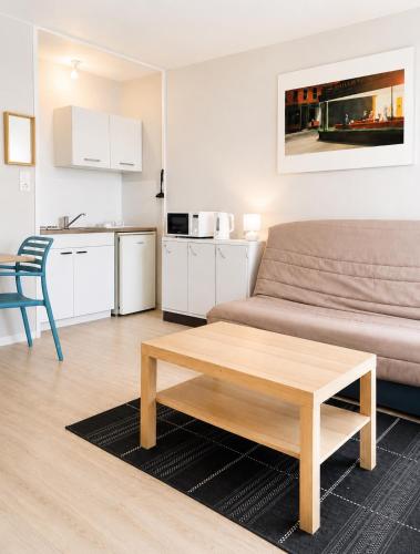 a living room with a couch and a coffee table at Studio - Pleine Mer - 1 avenue des Pays de Monts - 1-1 in Saint-Jean-de-Monts