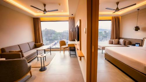 a hotel room with a bed and a living room at 7 Apple Hotel Visakhapatnam in Visakhapatnam