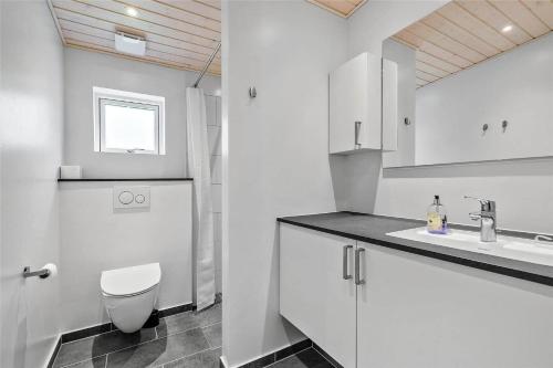 a white bathroom with a toilet and a sink at 8245-Knebel-Metholmvej-9 in Knebel