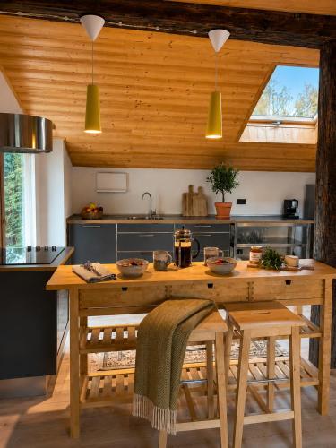 a kitchen with a wooden table with chairs and a sink at Mansarda Ossana in Fucine