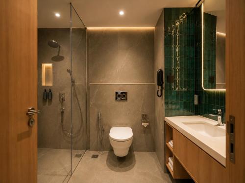 a bathroom with a shower and a toilet and a sink at 7 Apple Hotel Visakhapatnam in Visakhapatnam
