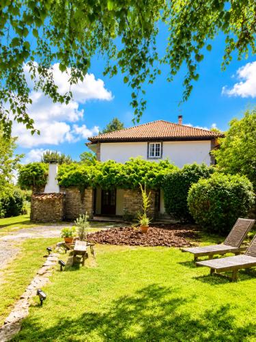 a garden with benches and a house in the background at Airtegal Casa do Pepe Cedeira in Cedeira
