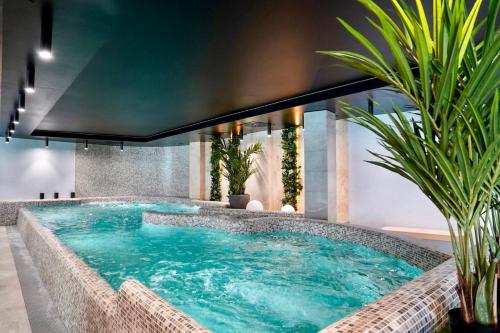 a large swimming pool in a hotel with plants at Baltic Waves Resort by Baltic Home in Międzyzdroje
