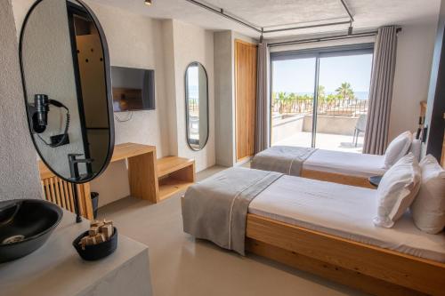 a hotel room with two beds and a mirror at Ayvalık Sea Long in Ayvalık