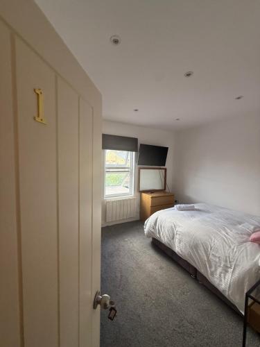 a bedroom with a bed and a window at Bel Palace in Hackbridge