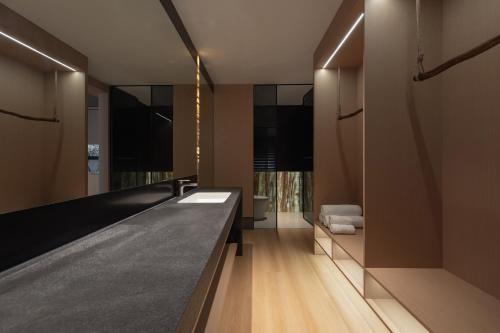 a bathroom with a long counter and a mirror at L'Eau Vive de Qixi Meidi - Riverfront Infinity Pool & Log Cabin Cafe - Outdoor Cooking Class - Complimentary Shuttle within 8 Kilometers in Yangshuo