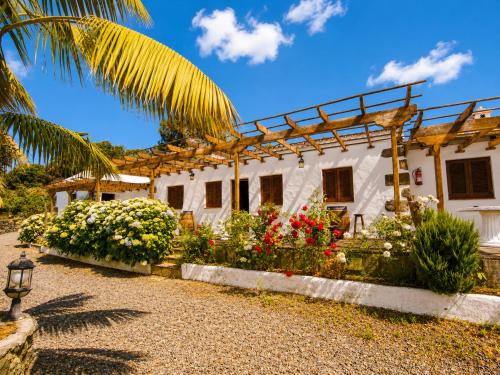 a house with a bunch of flowers in front of it at La Tanquera y Las Rosas in Los Realejos