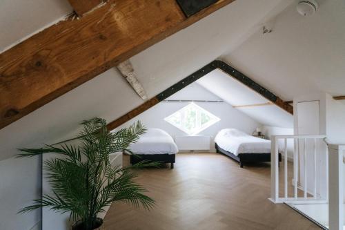 a attic bedroom with two beds and a plant at Oase in Bergen