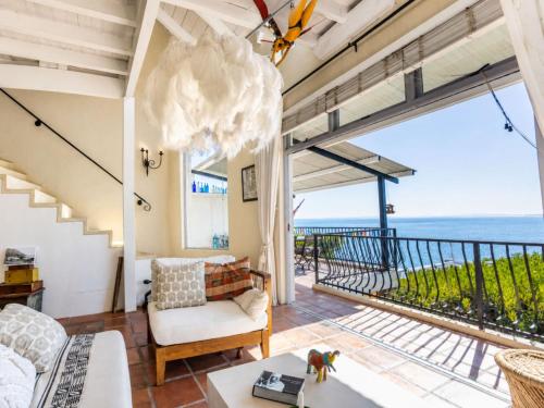 a living room with a view of the ocean at 'Cardamom House', Enchanting Vacation Home 2 min from the Beach, Sleeps 5 in Gordonʼs Bay