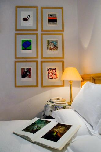 a book on a bed with pictures on the wall at Hotel Locanda Cairoli in Rome