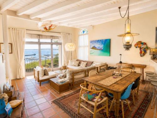 a living room with a table and a couch at 'Cardamom House', Enchanting Vacation Home 2 min from the Beach, Sleeps 5 in Gordonʼs Bay