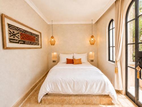 a bedroom with a white bed and a window at Riad Timoun in Agadir