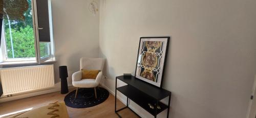 a living room with a chair and a black dresser at Cozy city appartement in Forchheim