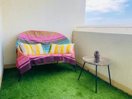 a chair sitting on a balcony with a table at Charmant appartement en front de mer avec piscine in Lacanau-Océan