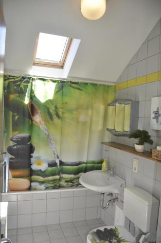 a bathroom with a shower curtain and a sink at Ferienwohnung Wildgatter in Grafenwiesen
