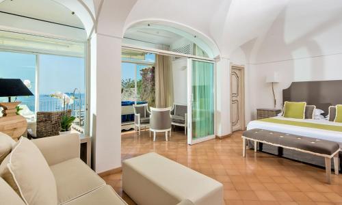 a bedroom with a bed and a living room at Hotel L'Ancora in Positano