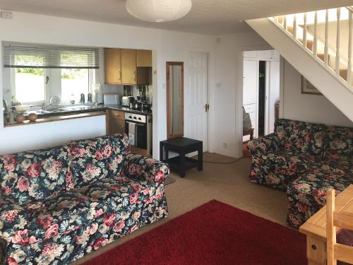a living room with a couch and a kitchen at Ruach in Gardenstown