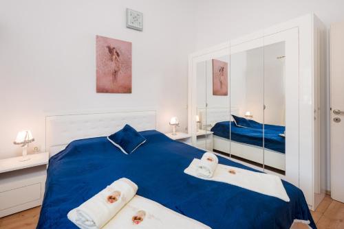 a bedroom with a blue bed with two towels at Villa Dea in Vučevica