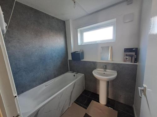 a bathroom with a sink and a bath tub and a sink at E Gardens Apartment in Nottingham
